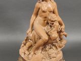 an image of a statue of a woman sitting on a rock