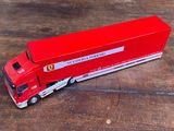 un camion rouge posé sur un plancher en bois