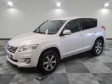 La Toyota RAV blanche est garée sur un sol en carrelage à damier.