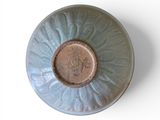 a blue bowl with a brown center on a white surface