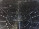 a close up of a metal plate with writing on it