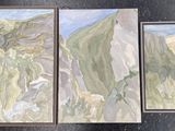 trois tableaux représentant une chaîne de montagnes sont exposés sur un fond noir