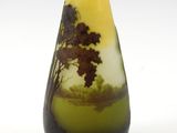 a yellow vase with a tree in it on a white surface