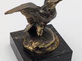 an image of a bronze statue of a bird on a marble base