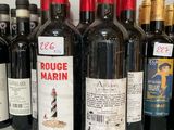 several bottles of red wine are lined up on a counter