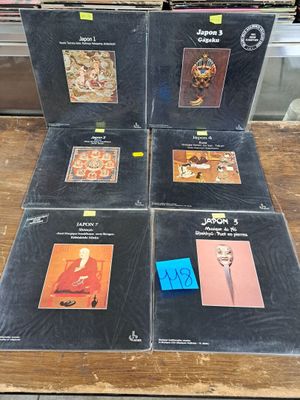 six lp ' s in a box on a table in a store