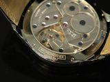 a close up of a watch on a black surface