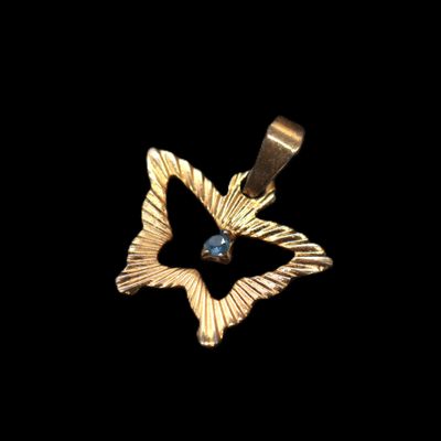 a close up of a gold pendant on a black background