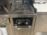 une cuisine équipée d'une cuisinière, d'un four, d'un évier et d'un plan de travail