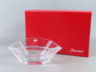 La boîte rouge se trouve à côté du bol en verre sur la table.