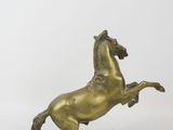 brass statue of a horse on its hind legs on a white background