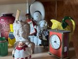 a shelf that has a clock, a clock and a figurine on it