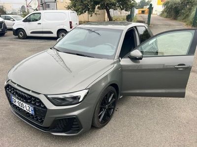 a grey audi car parked in a parking lot with its door open
