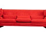 Le canapé rouge est posé sur un sol blanc, avec des coussins.