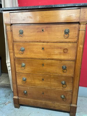 une vieille commode avec un plateau en marbre dans une pièce
