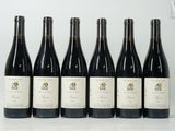 six bouteilles de vin sont alignées sur une table