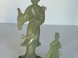 une statue représentant une femme et un enfant, posée sur une table