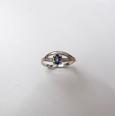 Gros plan sur une bague ornée d'une pierre bleue