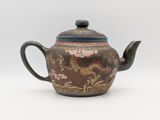 an image of a teapot with a dragon design on it