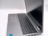a silver laptop with a black keyboard on a white surface