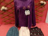 purple sweater with penguin applique and matching pants on a pink bed