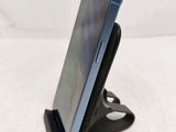 the back of a cell phone on a stand on a white surface