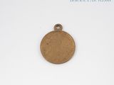 an image of a small bronze medal on a white surface