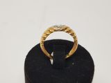 a close up of a gold ring on a black ring stand