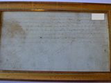 an old document is hanging on a wall next to a blue wall