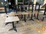 several tables and chairs on a wooden deck outside of a restaurant