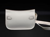 a white purse with a strap hanging from it ' s side on a black background