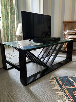 a glass coffee table with a television on it