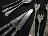 five forks and a knife on a black table