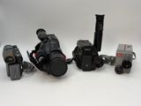 three cameras and a video camera on a white surface