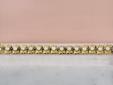 un gros plan d'un bracelet en or orné de perles