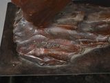 a bronze statue of a man with a knife in his hand