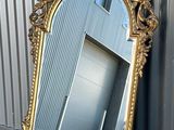 un miroir posé par terre près d'un mur
