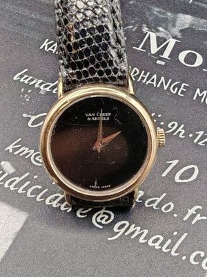 une montre noire et dorée posée sur un livre