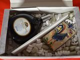 a box with a bottle of liquor and a pen in it