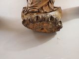 a statue of a woman sitting on top of a rock