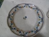 a plate with a flower design on it sitting on a table