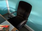 a black office chair sitting in front of a blue wall