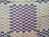 a large checkered blanket hanging on a clothes rack