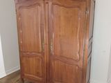 a wooden cabinet in the corner of a room