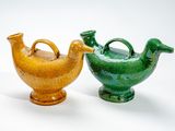 deux vases posés l'un à côté de l'autre sur une surface blanche