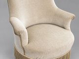 une chaise rembourrée avec des franges sur les pieds