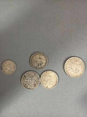 four different types of coins are shown on a gray surface