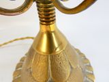 a gold candle holder with a blue flower on top of it