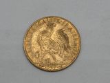 a close up of a gold coin on a white surface