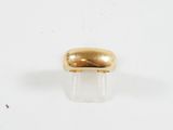 gros plan d'une bague en or sur une surface blanche